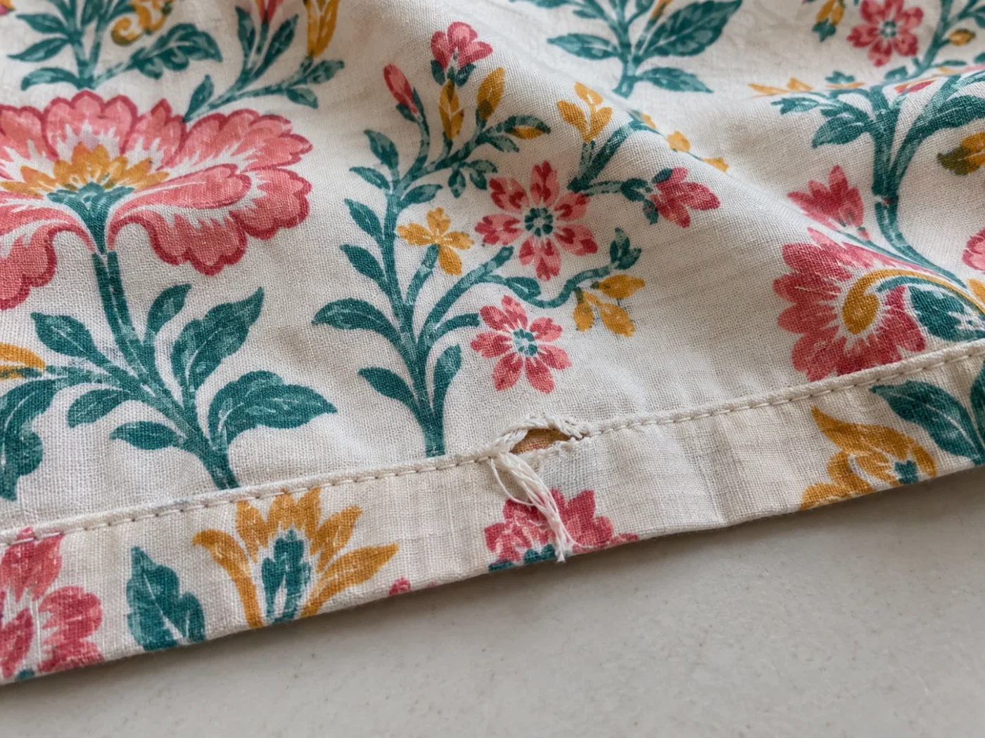 Illustrative example of a small torn seam on a colourful floral bedsheet